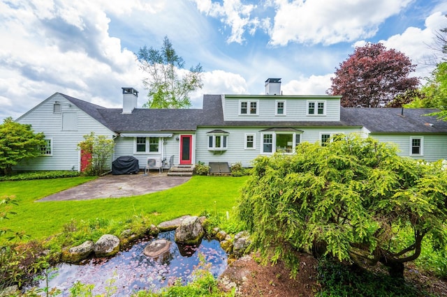 51 Carter Rd, New London, NH 03257 - rear view of property featuring entry steps, a chimney, a patio area, a yard, and a small pond