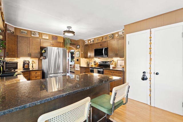 228 Platts Ave, Manchester, NH 03109 - kitchen with stainless steel appliances, a peninsula, backsplash, and a kitchen bar