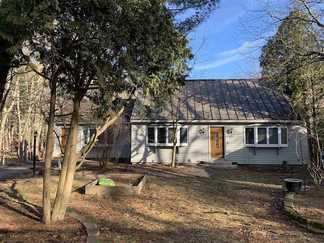 424 Main Dunstable Rd, Nashua, NH 03062 - view of front of home with a vegetable garden, a standing seam roof, and metal roof