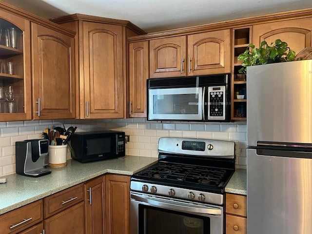 424 Main Dunstable Rd, Nashua, NH 03062 - kitchen with stainless steel appliances, brown cabinets, glass insert cabinets, and open shelves