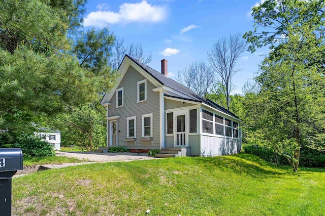2124 Wakefield Rd, Wakefield, NH 03872 - view of front of home with a chimney, a sunroom, and a front yard