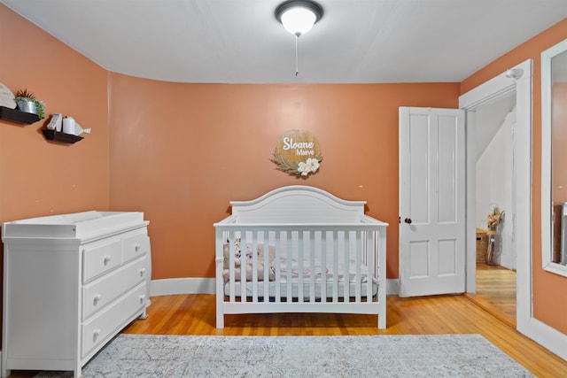 2124 Wakefield Rd, Wakefield, NH 03872 - bedroom with wood finished floors, baseboards, and a nursery area