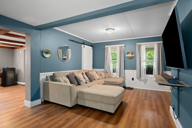 2124 Wakefield Rd, Wakefield, NH 03872 - living area with a barn door, wood finished floors, wainscoting, beam ceiling, and ornamental molding