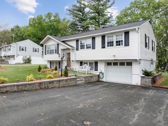 127 Shore Dr, Nashua, NH 03062 - raised ranch featuring driveway, an attached garage, a front lawn, and a shingled roof