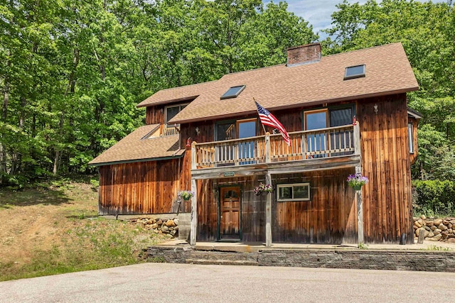 222 Main St, Alton, NH 03809 - chalet / cabin with roof with shingles, a chimney, and a balcony