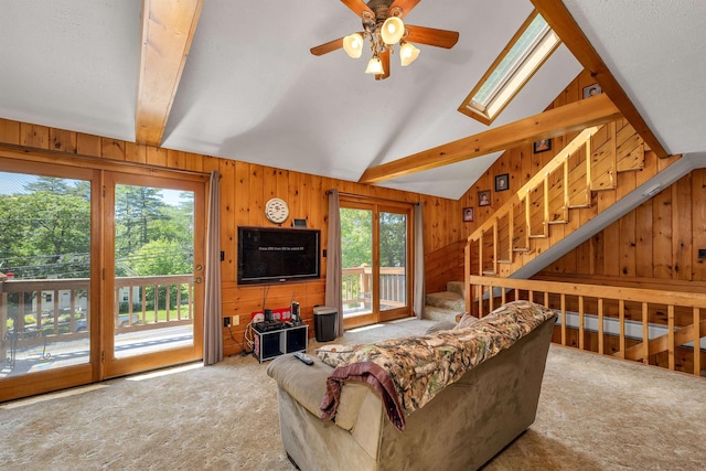 222 Main St, Alton, NH 03809 - living room with carpet flooring, wood walls, ceiling fan, beamed ceiling, and stairway