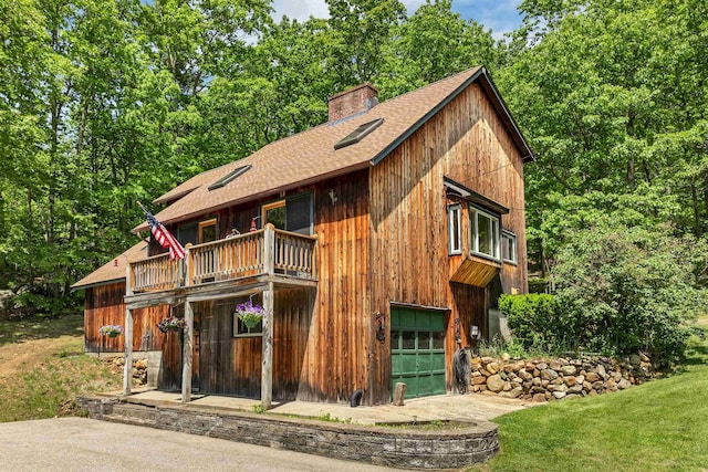 222 Main St, Alton, NH 03809 - chalet / cabin featuring a balcony, a shingled roof, a garage, a chimney, and a front lawn