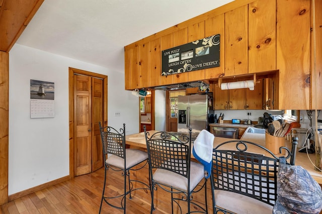 222 Main St, Alton, NH 03809 - kitchen with appliances with stainless steel finishes, light wood-type flooring, baseboards, and brown cabinetry
