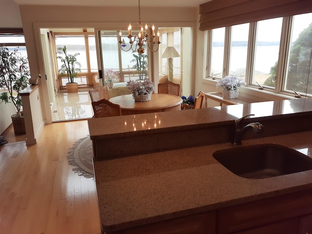 11 Portside Dr Unit 5, Moultonborough, NH 03254 - dining space featuring a chandelier, light wood-style floors, healthy amount of natural light, and a water view