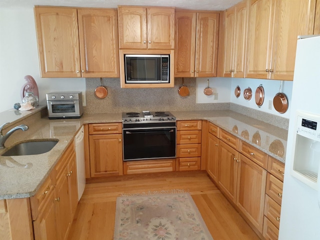 11 Portside Dr Unit 5, Moultonborough, NH 03254 - kitchen with white appliances, light wood-type flooring, a sink, light stone counters, and a peninsula