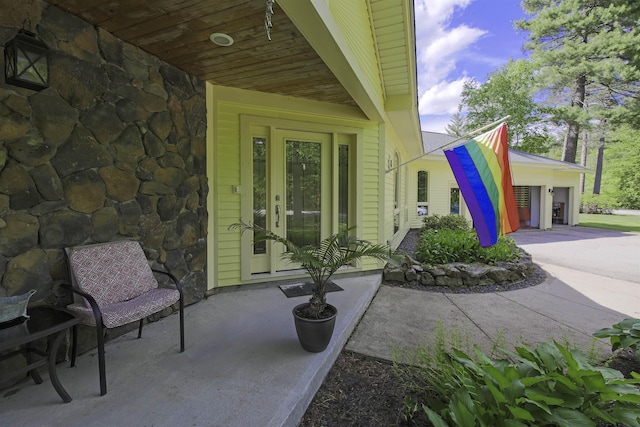 16 Carleton Way, Hales Location, NH 03860 - property entrance featuring stone siding and a garage