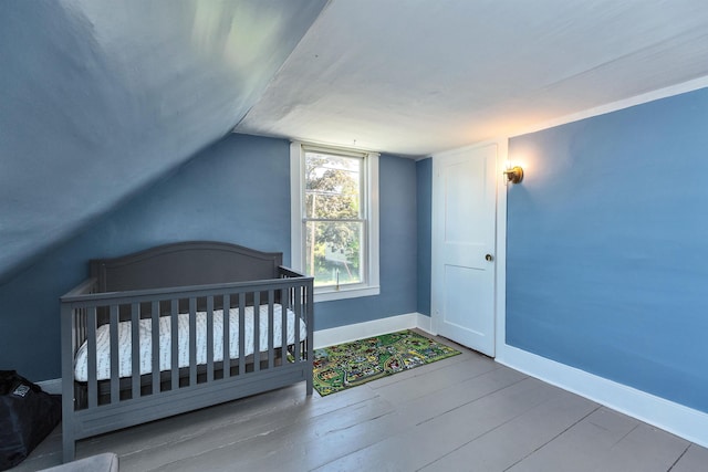 90 Sullivan St, Claremont, NH 03743 - unfurnished bedroom featuring baseboards, vaulted ceiling, and wood finished floors