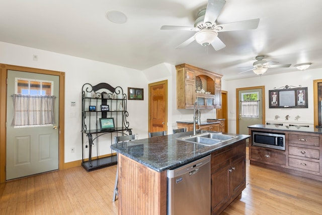 628 S Main St, Brattleboro, VT 05301 - kitchen with stainless steel appliances, a sink, a ceiling fan, light wood-style flooring, and a breakfast bar