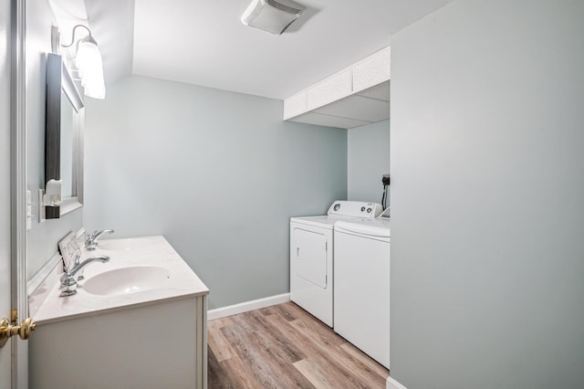 19 Abbott Rd, Concord, NH 03303 - bathroom featuring separate washer and dryer, double vanity, wood finished floors, baseboards, and lofted ceiling