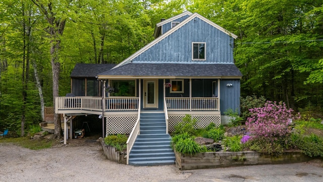 5 Adams Rd, Jackson, NH 03846 - view of front of house with roof with shingles, stairway, covered porch, and a view of trees