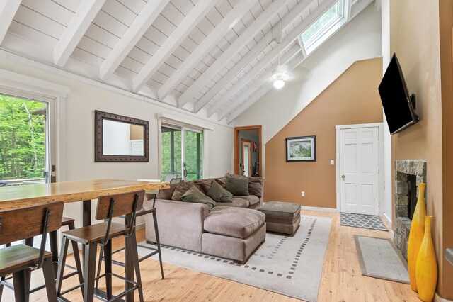 5 Adams Rd, Jackson, NH 03846 - living area with healthy amount of natural light, light wood-style flooring, a stone fireplace, high vaulted ceiling, and wooden ceiling with exposed beams