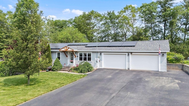 22 Westray Dr, Nashua, NH 03062 - view of front of property featuring an attached garage, asphalt driveway, a front yard, and roof mounted solar panels