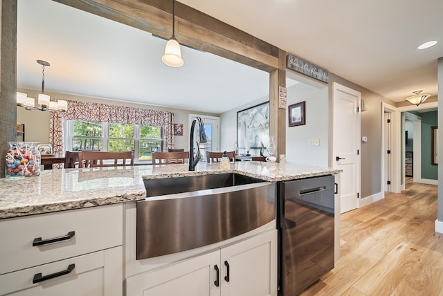 22 Westray Dr, Nashua, NH 03062 - kitchen with a sink, light wood finished floors, dishwashing machine, hanging light fixtures, and white cabinets