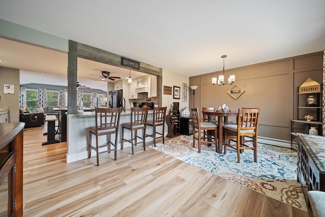 22 Westray Dr, Nashua, NH 03062 - dining room with light wood finished floors, a decorative wall, a ceiling fan, and a chandelier