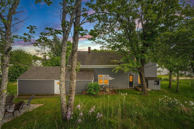 9 Grove Rd, Lyndeborough, NH 03082 - back of house at dusk with a yard, a shingled roof, and a chimney
