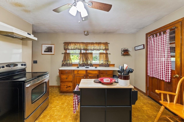 780 Greenfield Rd, Peterborough, NH 03458 - kitchen with stainless steel range with electric cooktop, light countertops, a sink, brown cabinets, and ceiling fan