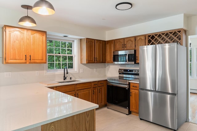 179 Arbor Ln, Colchester, VT 05446 - kitchen with stainless steel appliances, a sink, light countertops, pendant lighting, and brown cabinets
