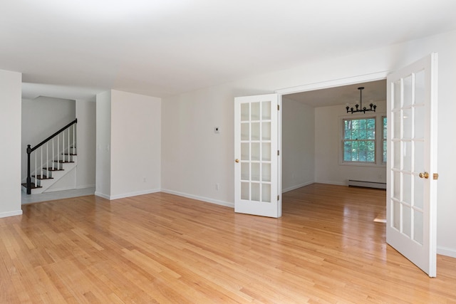 179 Arbor Ln, Colchester, VT 05446 - spare room featuring french doors, a chandelier, light wood finished floors, and stairway