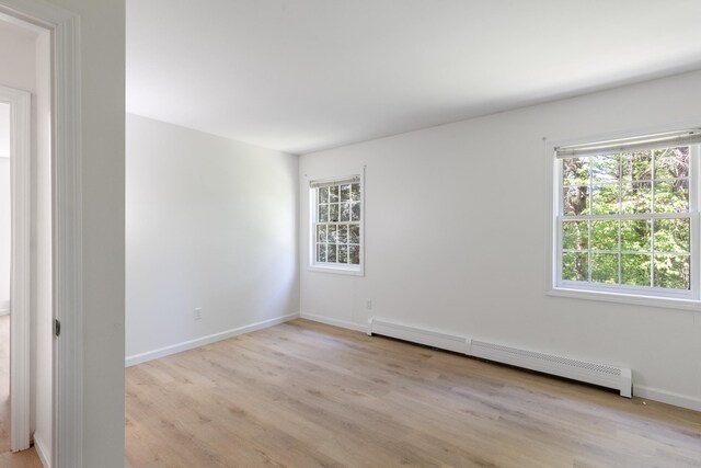 179 Arbor Ln, Colchester, VT 05446 - empty room with a baseboard heating unit, light wood finished floors, and baseboards
