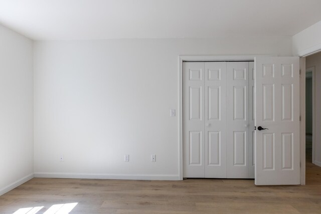 179 Arbor Ln, Colchester, VT 05446 - unfurnished bedroom with light wood-style floors, a closet, and baseboards
