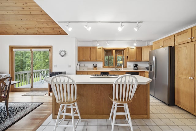 263 Old Post Rd, Newbury, NH 03255 - kitchen with stainless steel fridge, a sink, rail lighting, light countertops, and a breakfast bar
