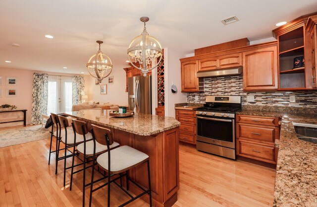 65 Victoria St Unit 8, Manchester, NH 03104 - kitchen with appliances with stainless steel finishes, under cabinet range hood, a chandelier, light wood-style floors, and recessed lighting