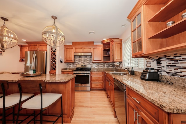 65 Victoria St Unit 8, Manchester, NH 03104 - kitchen featuring stainless steel appliances, open shelves, a chandelier, a sink, and a breakfast bar