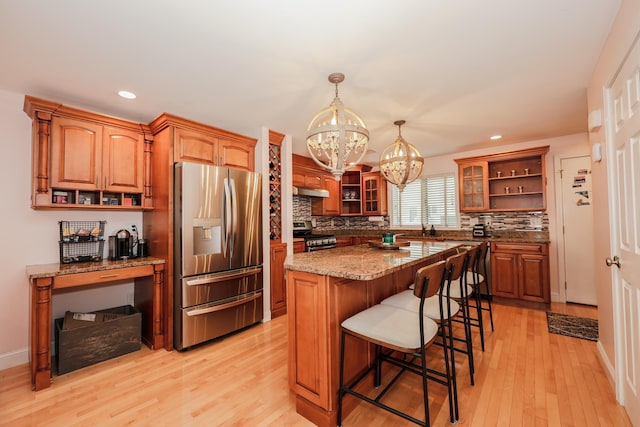 65 Victoria St Unit 8, Manchester, NH 03104 - kitchen featuring appliances with stainless steel finishes, open shelves, a chandelier, light wood-style floors, and tasteful backsplash