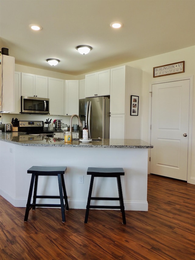 127 Holland Ln Unit 6, Williston, VT 05495 - kitchen featuring stainless steel appliances, dark stone countertops, a kitchen bar, and recessed lighting