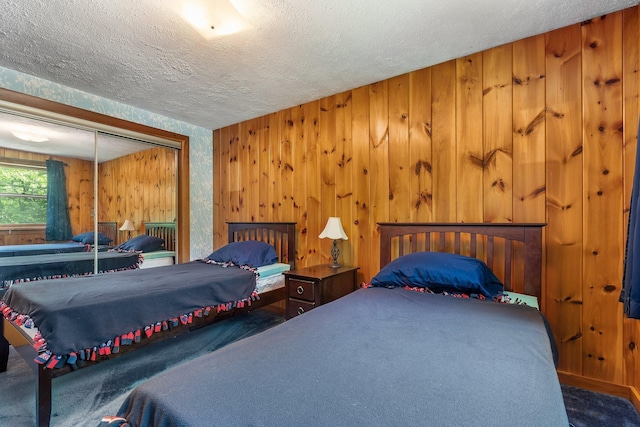 16 Mckinnon Rd, Washington, NH 03280 - bedroom with carpet, a textured ceiling, a closet, and wooden walls