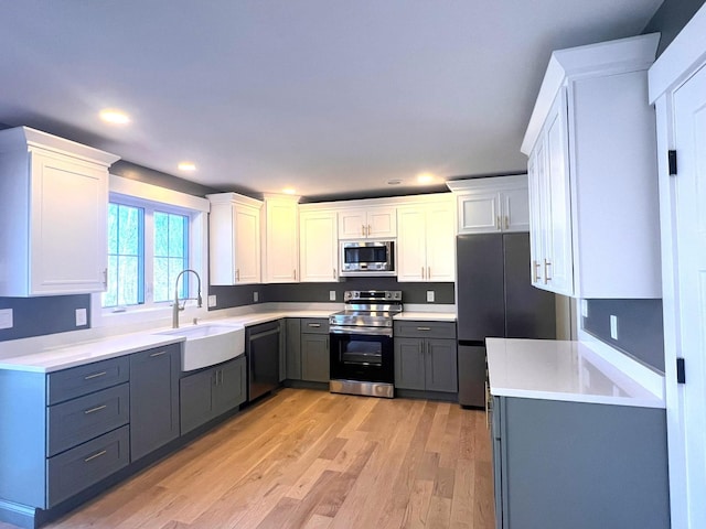 3 Crocket St, Rochester, NH 03867 - kitchen featuring stainless steel appliances, a sink, light wood finished floors, white cabinetry, and recessed lighting