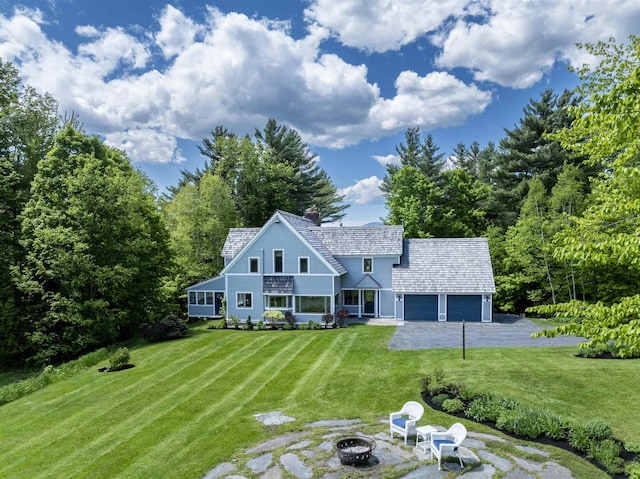 188 Foster Farm Rd, Stowe, VT 05672 - view of front of property with an outdoor fire pit, a garage, a front yard, a chimney, and driveway