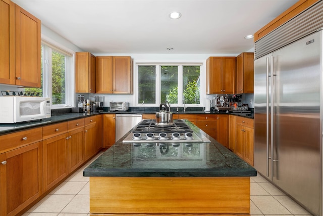 188 Foster Farm Rd, Stowe, VT 05672 - kitchen with appliances with stainless steel finishes, light tile patterned floors, a kitchen island, brown cabinets, and recessed lighting