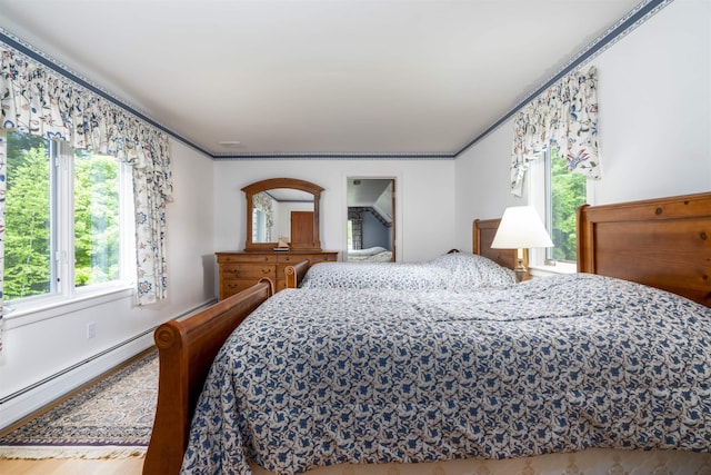 188 Foster Farm Rd, Stowe, VT 05672 - bedroom with ornamental molding, a baseboard heating unit, and wood finished floors