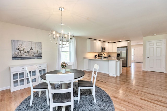 264 Woodview Way, Manchester, NH 03102 - dining area with a chandelier, light wood finished floors, and baseboards