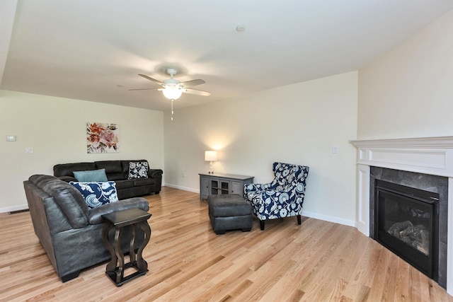 264 Woodview Way, Manchester, NH 03102 - living area featuring light wood finished floors, a ceiling fan, a glass covered fireplace, and baseboards