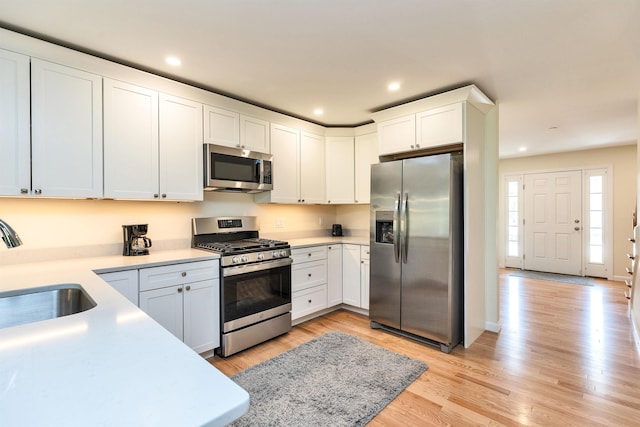 264 Woodview Way, Manchester, NH 03102 - kitchen featuring stainless steel appliances, a sink, light countertops, light wood-style flooring, and recessed lighting