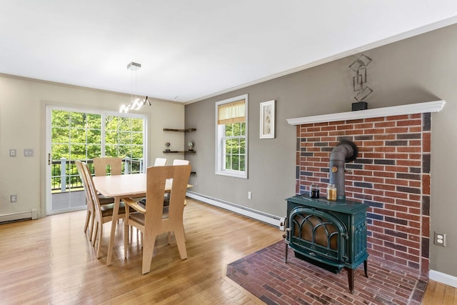 12 Old Fort Ln, Dunbarton, NH 03046 - dining space with baseboard heating, a wood stove, wood finished floors, a chandelier, and baseboards