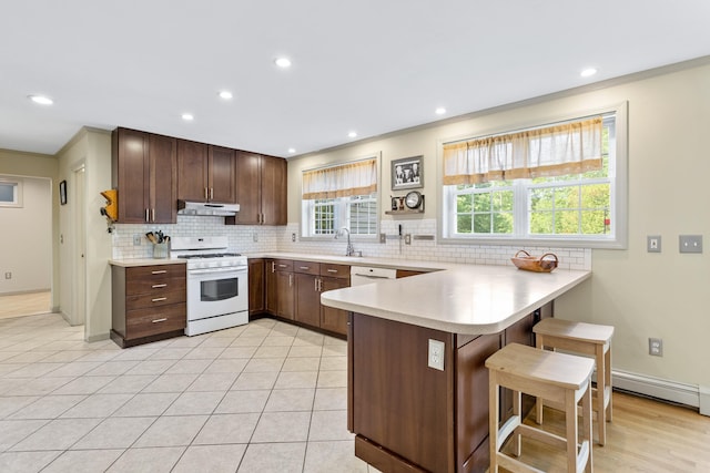 12 Old Fort Ln, Dunbarton, NH 03046 - kitchen with white gas range oven, under cabinet range hood, a peninsula, a sink, and light countertops