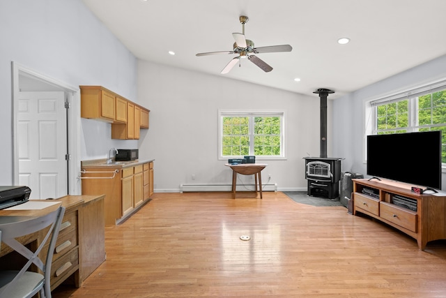 12 Old Fort Ln, Dunbarton, NH 03046 - living room with a baseboard radiator, vaulted ceiling, a wood stove, ceiling fan, and light wood-style floors