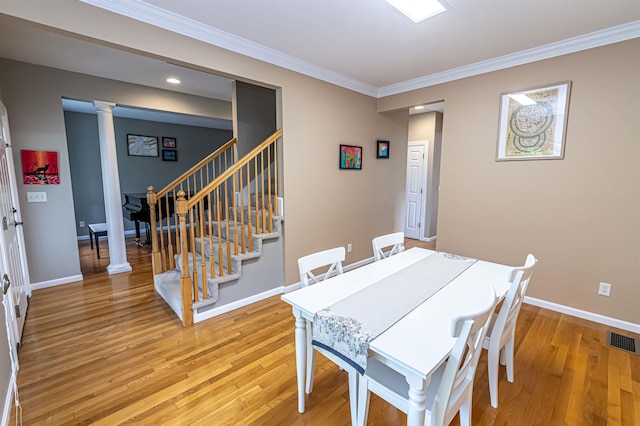 1 Tether Rd, Bedford, NH 03110 - dining space with decorative columns, light wood-style flooring, stairs, crown molding, and baseboards