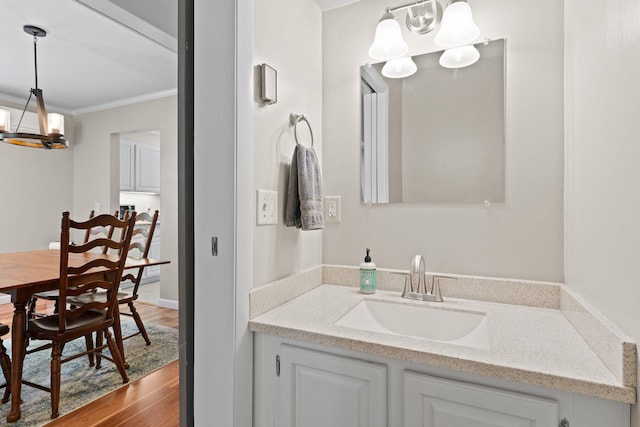 14 Hideaway Ln, Williston, VT 05495 - bathroom featuring a chandelier, ornamental molding, vanity, and wood finished floors