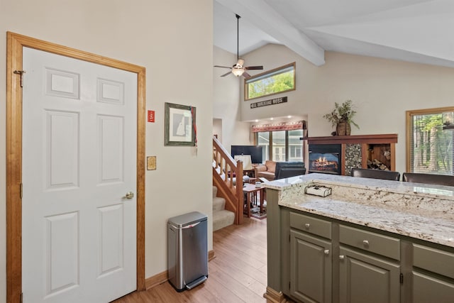 10 Mountain Brook Cir Unit 2, Lincoln, NH 03251 - kitchen with gray cabinetry, open floor plan, light wood finished floors, beam ceiling, and a glass covered fireplace