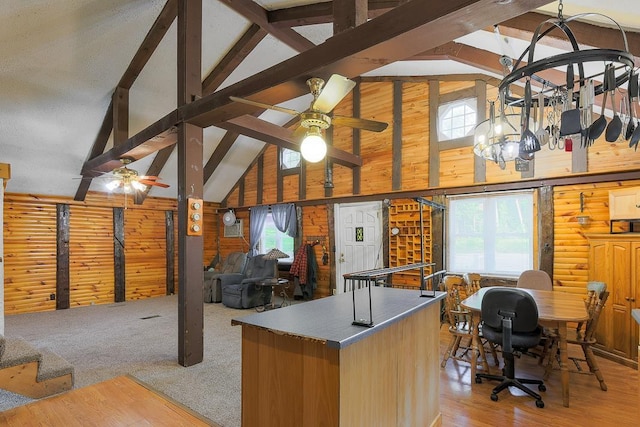 594 Suncook Valley Rd, Alton, NH 03809 - kitchen featuring a ceiling fan, high vaulted ceiling, open floor plan, wooden walls, and beamed ceiling