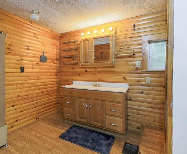 594 Suncook Valley Rd, Alton, NH 03809 - bathroom with rustic walls, vanity, wood finished floors, and a textured ceiling